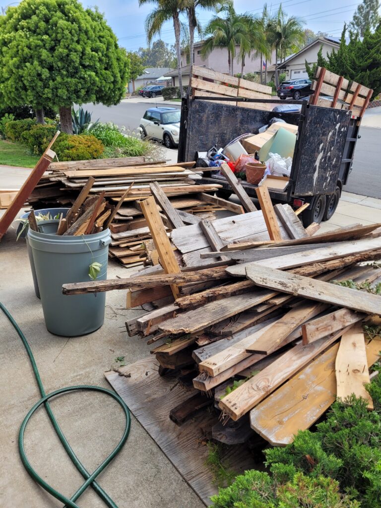Wood debris and construction materials stacked for residential debris removal in San Marcos, CA