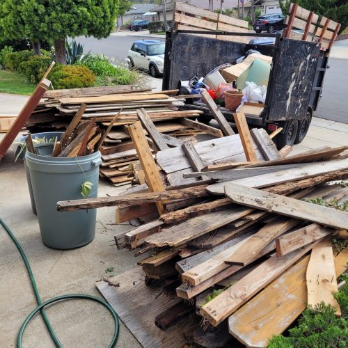 Wood debris and construction materials stacked for residential debris removal in San Marcos, CA